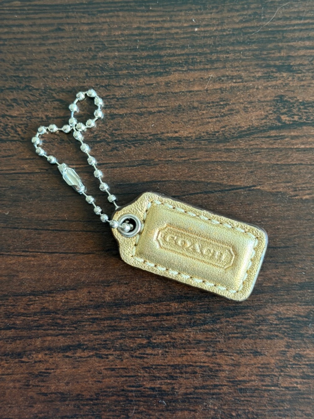 Coach gold leather hangtag